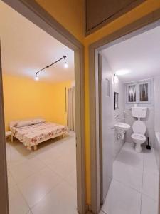 a bathroom with a toilet and a bed in it at Fellini Marcello garden (talpiot) in Haifa