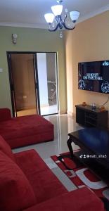 a living room with a red bed and a tv at 11036 in Ndola