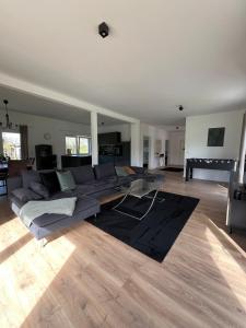 uma sala de estar com um sofá e uma mesa de vidro em HOME OF VACATION - Ferienhaus bei Celle nähe Hannover - FREE WIFI & Netflix em Adelheidsdorf