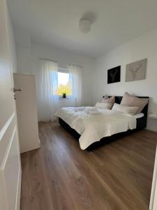 um quarto com uma cama grande e piso em madeira em HOME OF VACATION - Ferienhaus bei Celle nähe Hannover - FREE WIFI & Netflix em Adelheidsdorf