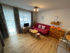 - un salon avec un canapé rouge et une table dans l'établissement Montanji 11, à Loèche-les-Bains