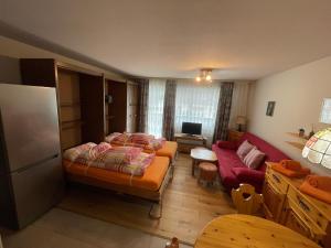 - une chambre avec un lit et un canapé rouge dans l'établissement Montanji 11, à Loèche-les-Bains