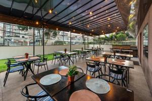 um restaurante com mesas, cadeiras e janelas em Flat Hotel Slaviero Guarulhos em Guarulhos