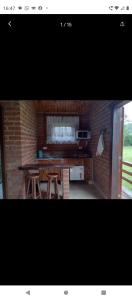 a kitchen with a table and a brick wall at Chalé São Benedito I in Santo Antônio do Pinhal