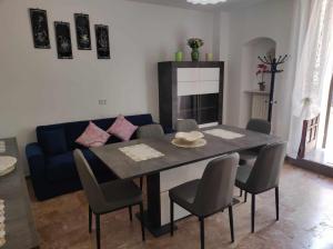 een eettafel met stoelen en een blauwe bank bij Appartamento Cuore Salento in Carmiano