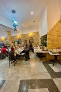 un restaurante con gente sentada en las mesas de una habitación en Costas Inn, en Spílion