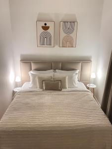 ein Schlafzimmer mit einem großen weißen Bett mit zwei Lampen in der Unterkunft Pisha Panoramic Rooms in Kruja