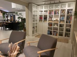 2 Stühle in einem Wohnzimmer mit Bücherregalen in der Unterkunft Nansen-Villa in Tromsø