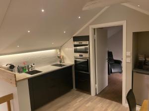a kitchen with black cabinets and an open door at Korsnäsgården in Dala-Järna