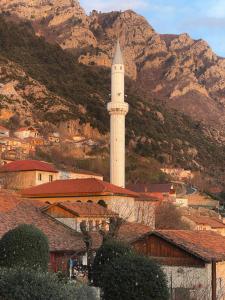 einen Uhrturm in einer Stadt mit Bergen im Hintergrund in der Unterkunft Pisha Panoramic Rooms in Kruja