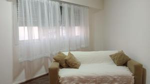 a bed with pillows sitting in front of a window at La Plata 1643 in La Plata