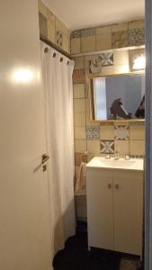 a bathroom with a sink and a shower curtain at La Plata 1643 in La Plata