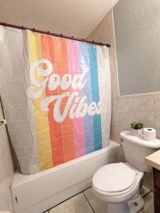 uma casa de banho com uma cortina de chuveiro colorida e um WC. em MiLuSol em Miami