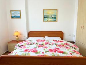 um quarto com uma cama grande com flores em Red by the sea em Golem