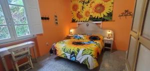 a bedroom with a bed and a painting of sunflowers at B&B Candalla in Camaiore