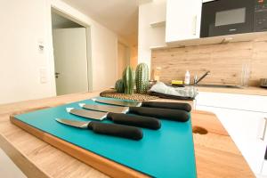 a blue cutting board with knives on a kitchen counter at 110 Lux Furnished flat in Beaufort