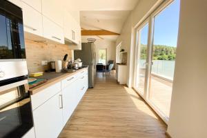 a kitchen with white cabinets and a large window at 310 Lux Furnished flat in Beaufort