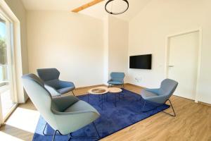 salon z 3 krzesłami i niebieskim dywanem w obiekcie 320 Lux Furnished flat w mieście Beaufort