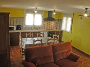 a living room with a couch and a table in a kitchen at casa rural la pallisa in Peñarroya de Tastavins