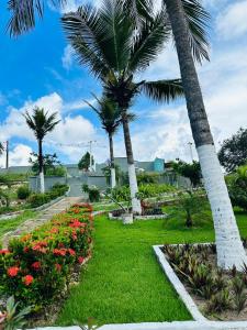 een tuin met palmbomen en bloemen in een park bij Pousada Recanto das Orquídeas in Barreirinhas