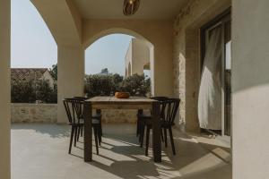 a dining room table and chairs on a patio at Sophisticated Preveza Villa Villa Harmony 2 Bedrooms Breathtaking Ionian Sea View And Private Pool Kanali Beach in Preveza +21 photos