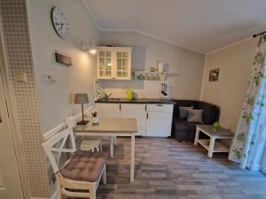 eine kleine Küche und ein Wohnzimmer mit einem Tisch und einer Theke in der Unterkunft Leśny zakątek apartament nr 5 in Radzyń