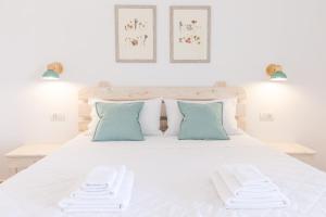 um quarto com uma cama branca e almofadas azuis em B&B Natura em San Teodoro