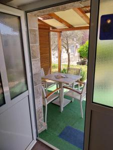 a table and chairs on a screened in porch at Petkovic Apartmani 2 in Tivat