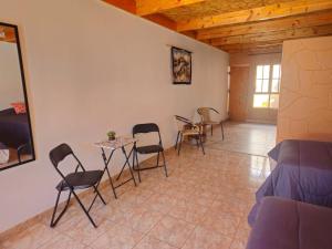 a room with chairs and a table and a bed at Hostal Belen in San Pedro de Atacama