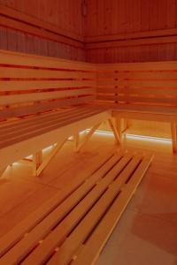 eine Holzbank in einem Zimmer mit Holzböden in der Unterkunft FoRest Domki & Spa in Adamówka