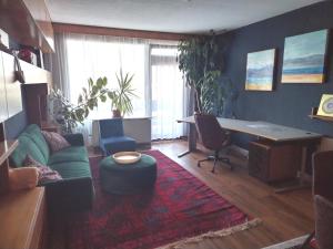 - un salon avec un canapé et un bureau dans l'établissement Waldeslust Villach Warmbad, à Villach