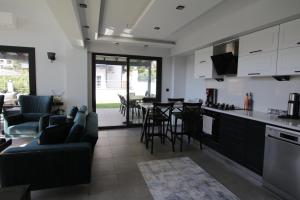 a kitchen and living room with a table and chairs at Marin Villaları Villa-2 in Marmaris