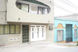 a white building with green doors and a window at Casa MoraZ Negro in Medellín