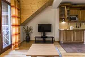 a living room with a television and a table at Apartament Giewont in Kościelisko