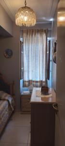 聖米格爾德圖庫曼的住宿－Los nietos alojamiento céntrico，小房间设有一张床和一个吊灯
