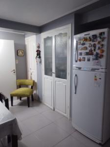 uma cozinha com um frigorífico branco e uma cadeira em Los nietos alojamiento céntrico em San Miguel de Tucumán