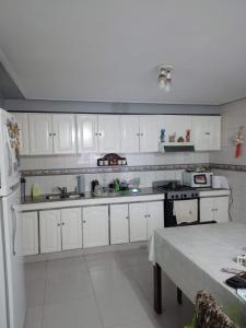 cocina con armarios blancos y nevera blanca en Los nietos alojamiento céntrico en San Miguel de Tucumán