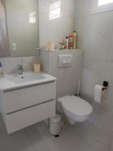 une salle de bains blanche avec toilettes et lavabo dans l'établissement Pa ni problème, à Saint-François