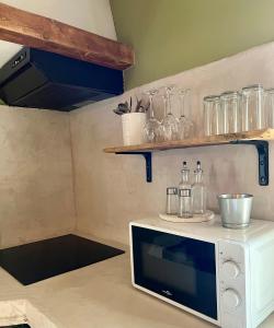 une petite cuisine avec un four micro-ondes sur un comptoir dans l'établissement Mazet en Provence, à Châteaurenard 5 autres photos