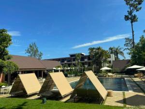 una piscina con due saloni e un resort di Hotel Pinar Dorado By Hotel Gran Jimenoa a Jarabacoa