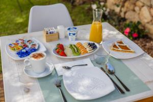 uma mesa com pratos de comida e uma chávena de café em B&B Natura em San Teodoro