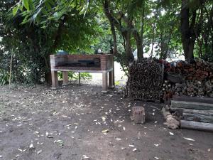 un banco de madera sentado junto a una pila de leña en El ranchito, en Santa Coloma