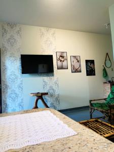 um quarto com uma cama e uma televisão na parede em Linda Kit Net Mobiliada Individual em Dourados