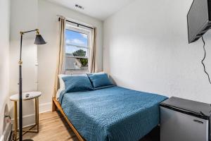 a small bedroom with a bed and a window at Satoshi Hideout Living - Rooms & Studios in St Petersburg