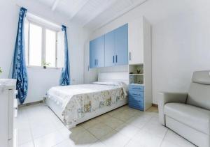 una camera bianca con armadi blu e un letto di Casa vacanze Cagliari Poetto a Quartu SantʼElena