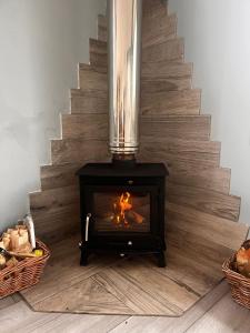 a fireplace on the floor next to a staircase at Country Cabin Retreat - Hideaway & Relax in Thornhill