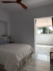 ein weißes Schlafzimmer mit einem Bett und einem Fenster in der Unterkunft Juliana 3 home in Sevilla