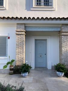 eine blaue Tür eines Hauses mit zwei Topfpflanzen in der Unterkunft Juliana 3 home in Sevilla
