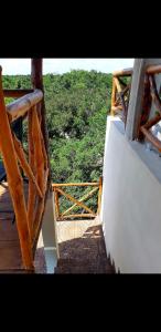 a wooden balcony with a view of a forest at Villa luna y sombra in Tulum