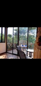 a room with a large window with a table and chairs at Villa luna y sombra in Tulum